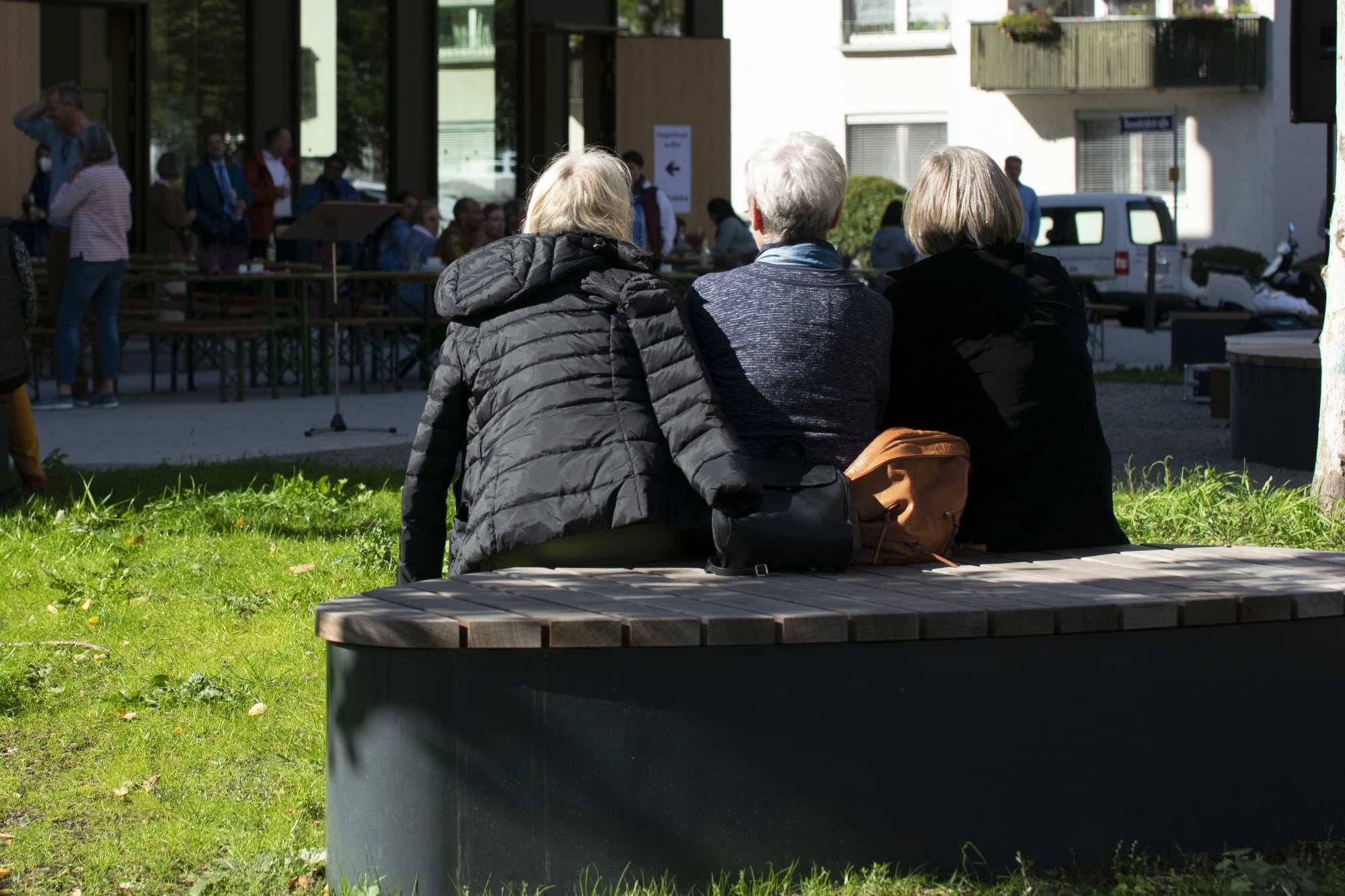 Quelle: ©EvKirchePF drei Menschen sitzen in der Sonne auf einer Sitzbank