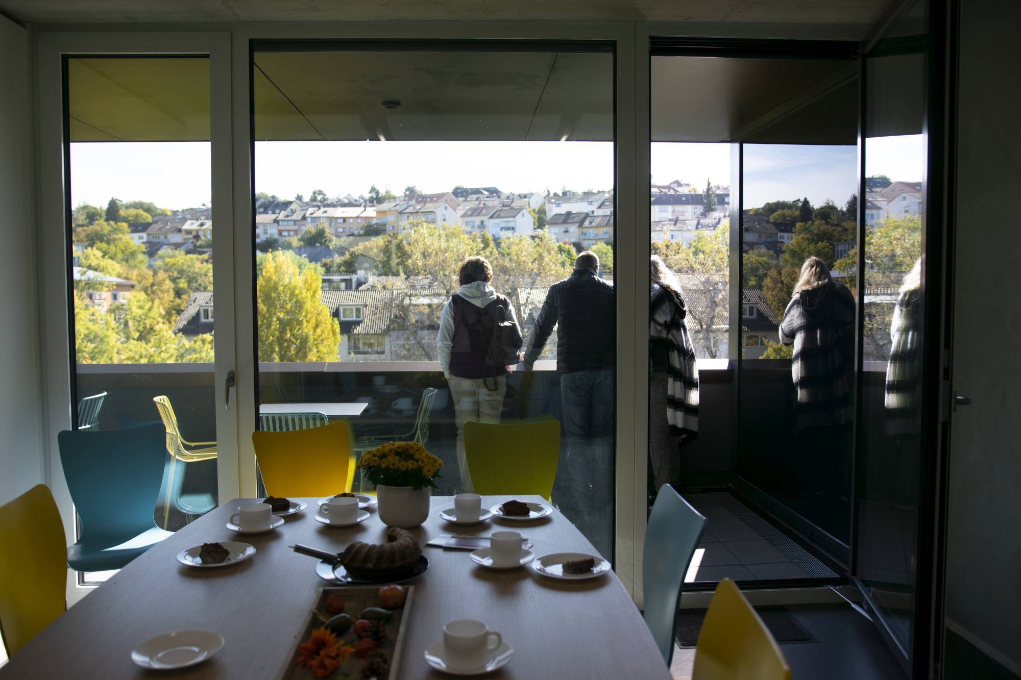 Quelle: ©EvKirchePF im Vordergrund gedeckter Tisch, im Hintergrund: Menschen auf einem Balkon