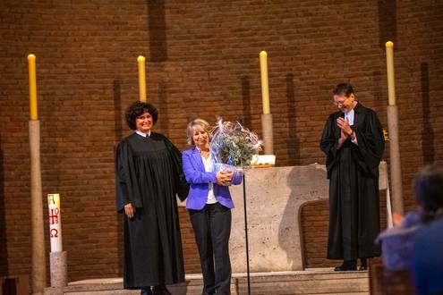 vor dem Altar in der Stadtkirche: Dekanin Christiane Quincke, Sabine Jost mit Blumenstrauß, Diakoniepfarrerin Martina Walter