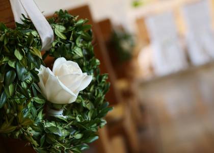 Holzbänke, an rechtem Ende Blumengesteck