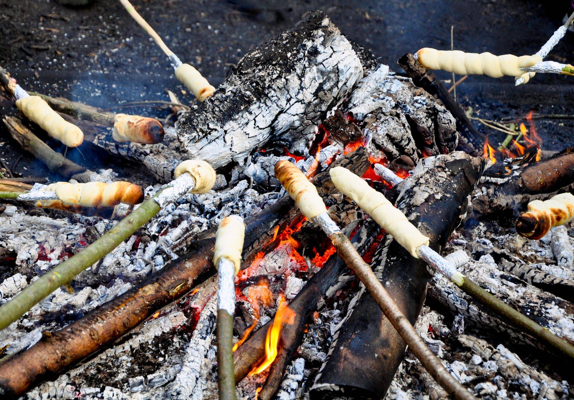 Am Lagerfeuer wird Stockbrot gebacken.